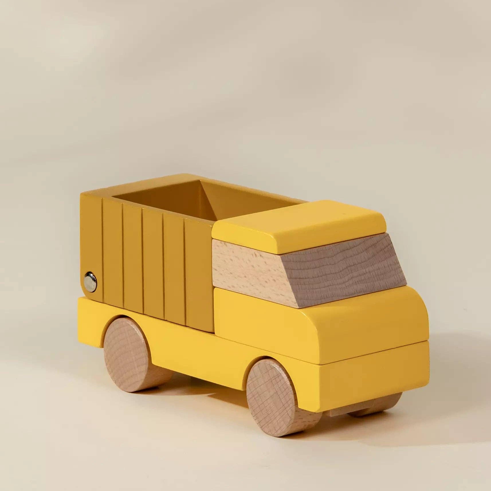 Yellow toy truck with wooden accents on a beige background