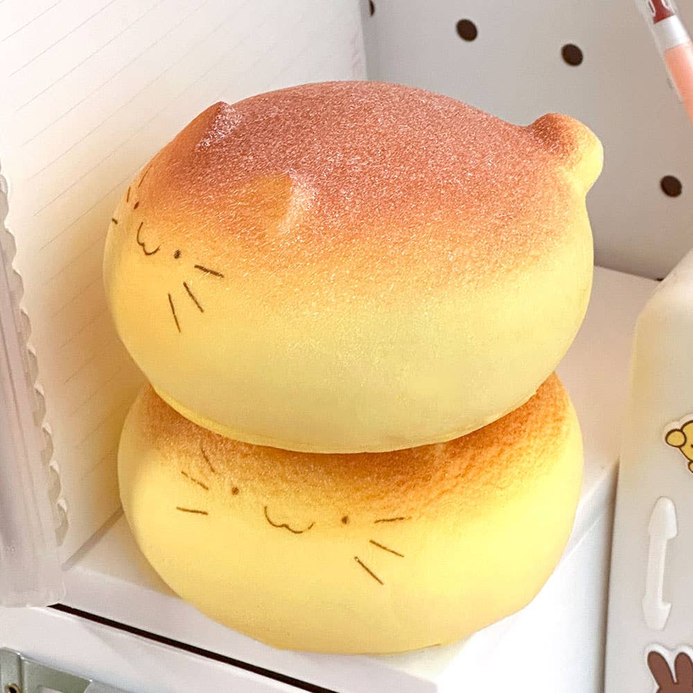 Two cat-shaped buns with faces on a white background