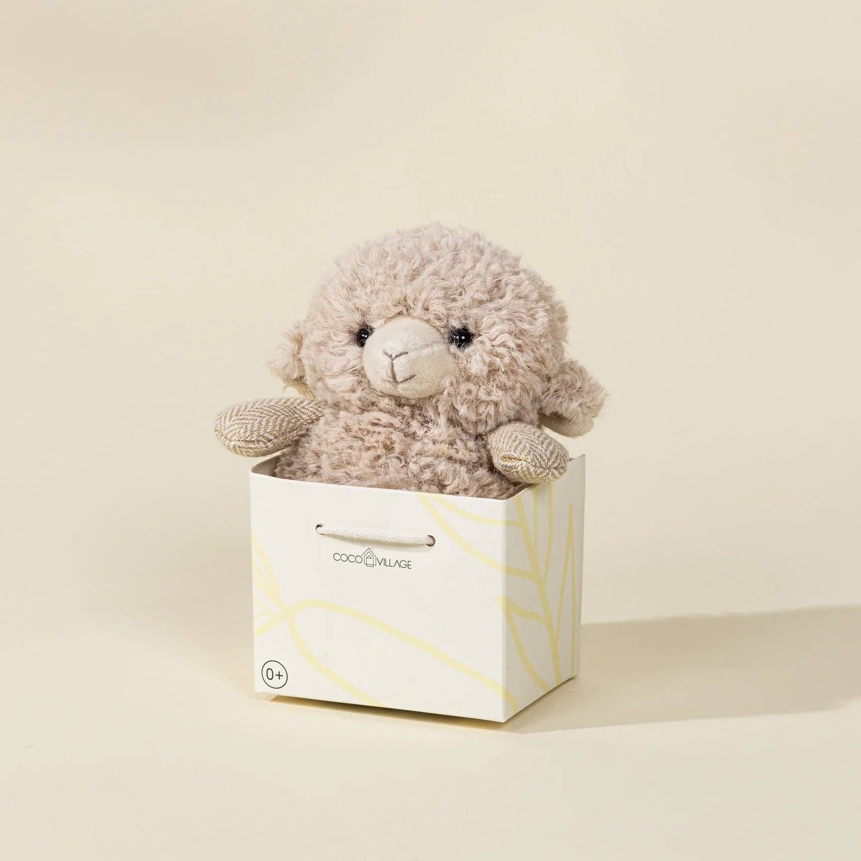 Stuffed animal toy in a white box on a beige background