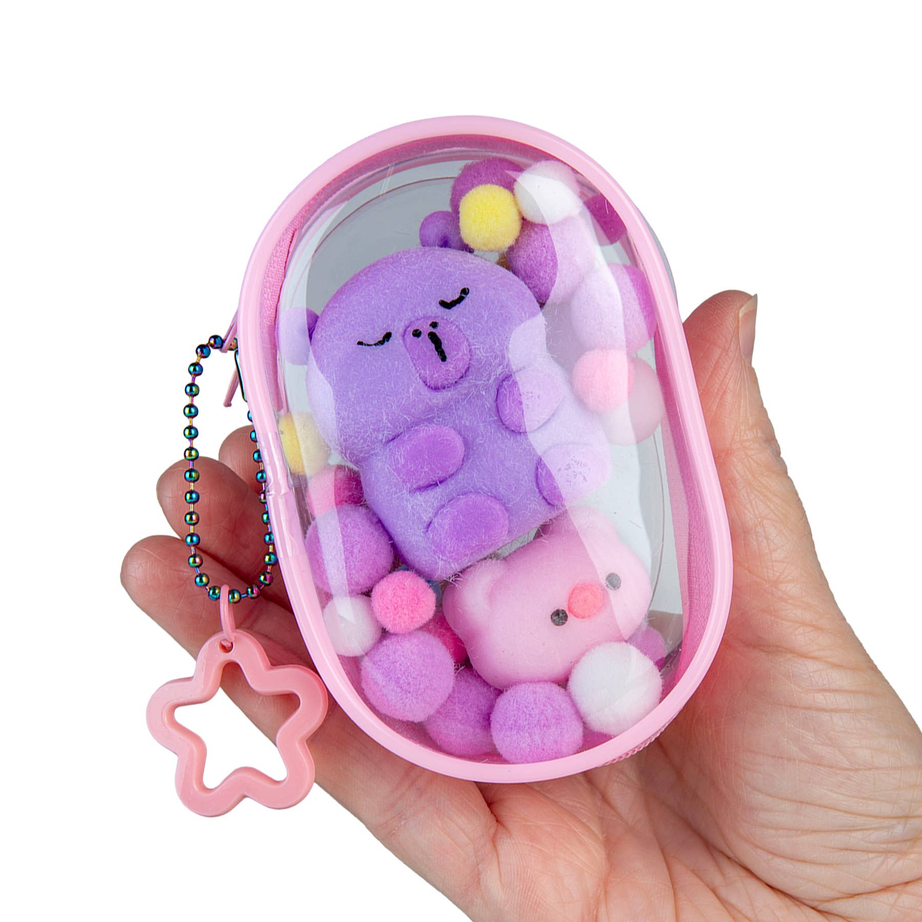 Hand holding a small pink container with plush toys inside, on a white background