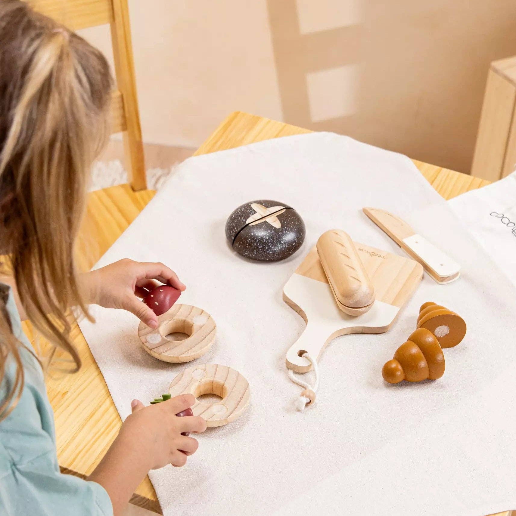 Child playing with toy food on a table