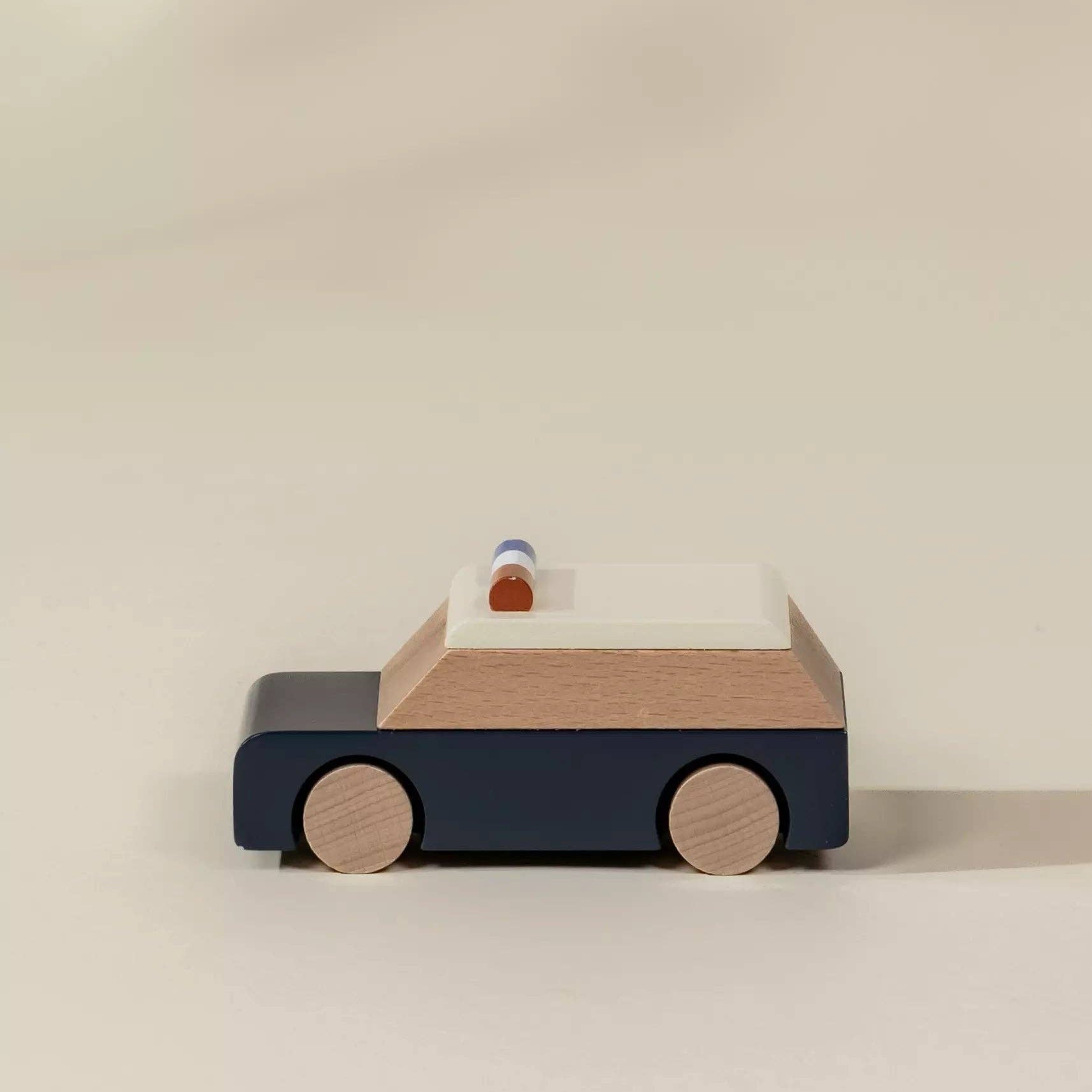 Wooden toy car with a blue body and wooden wheels on a beige background