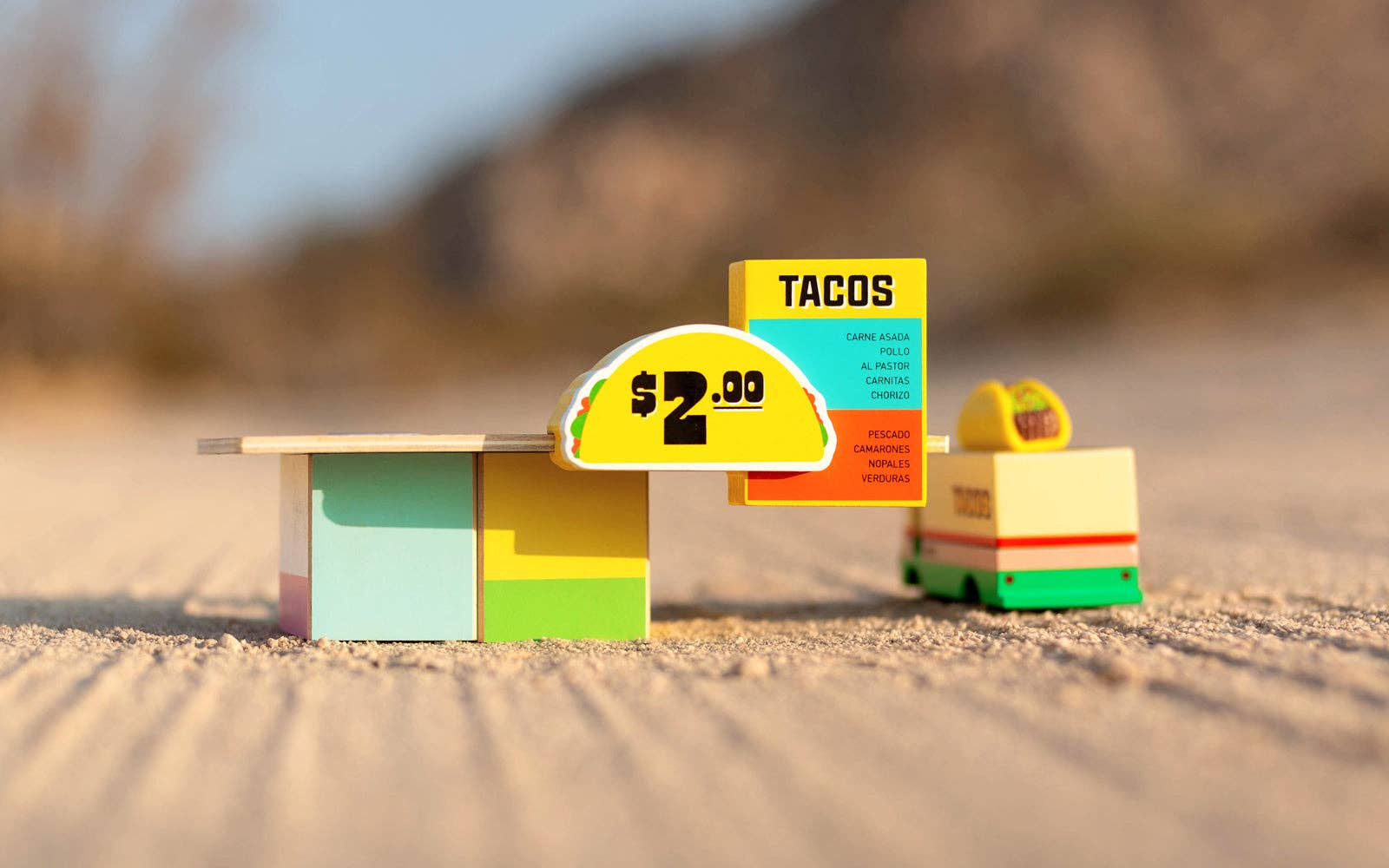 Toy taco stand with signs in a desert setting