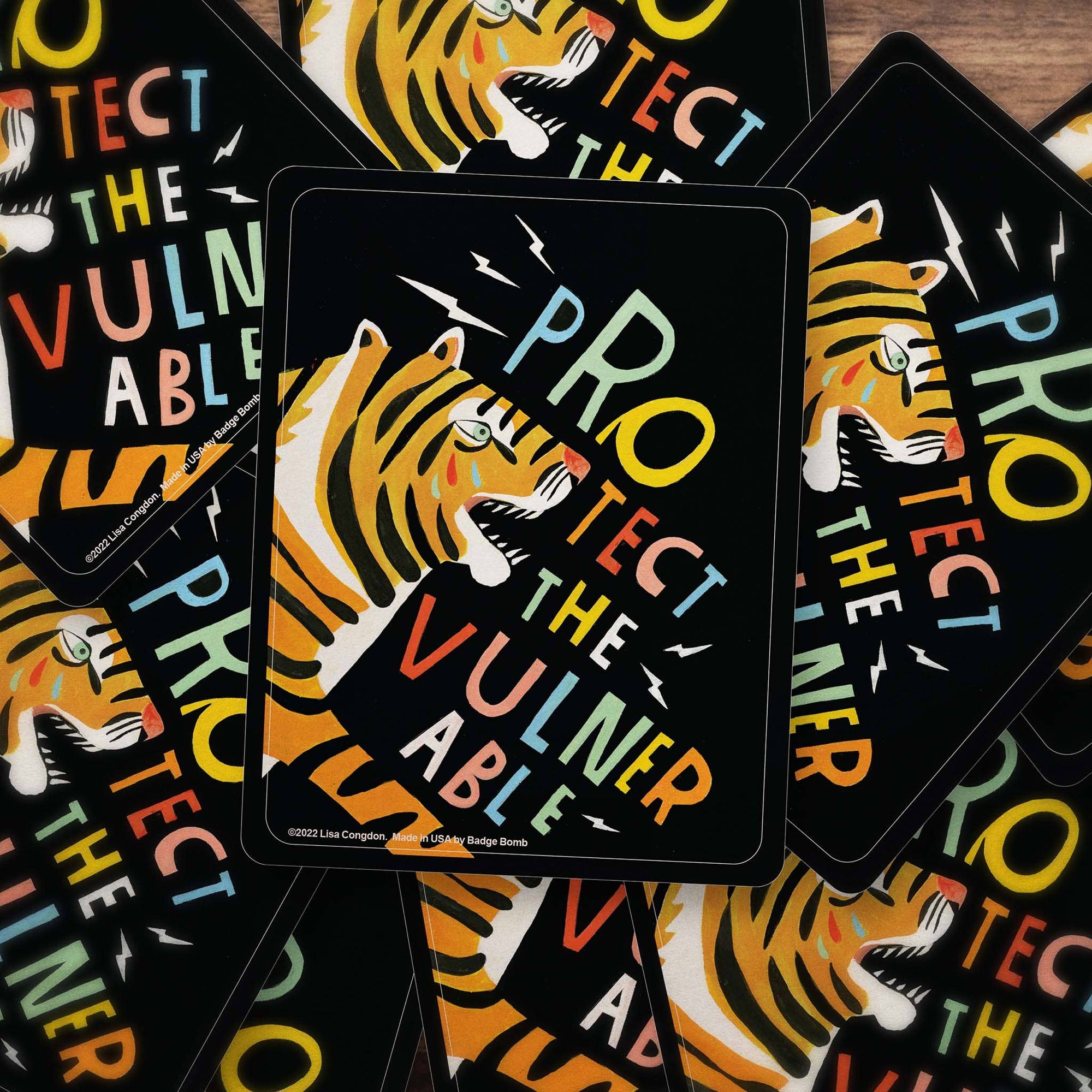 Stickers with tiger design and 'Protect the Vulnerable' text on a black background