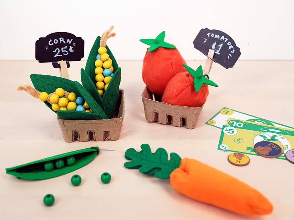 Felt vegetables and fruits with price tags on a beige background