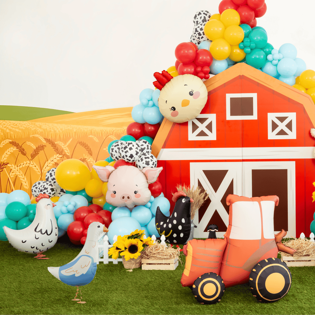 Colorful inflatable barn with farm animals and balloons on a grassy field