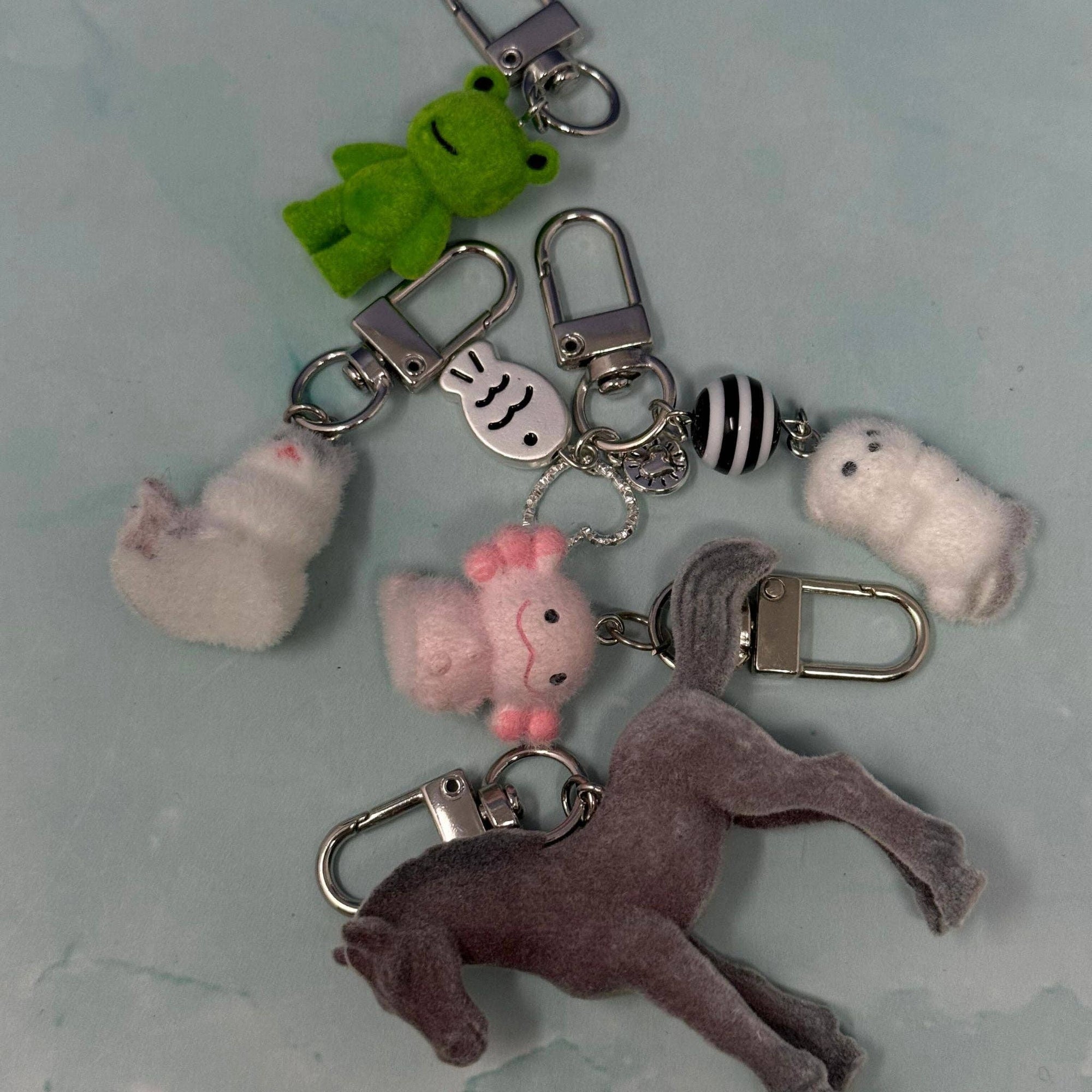 Keychain with various plush charms on a light blue background