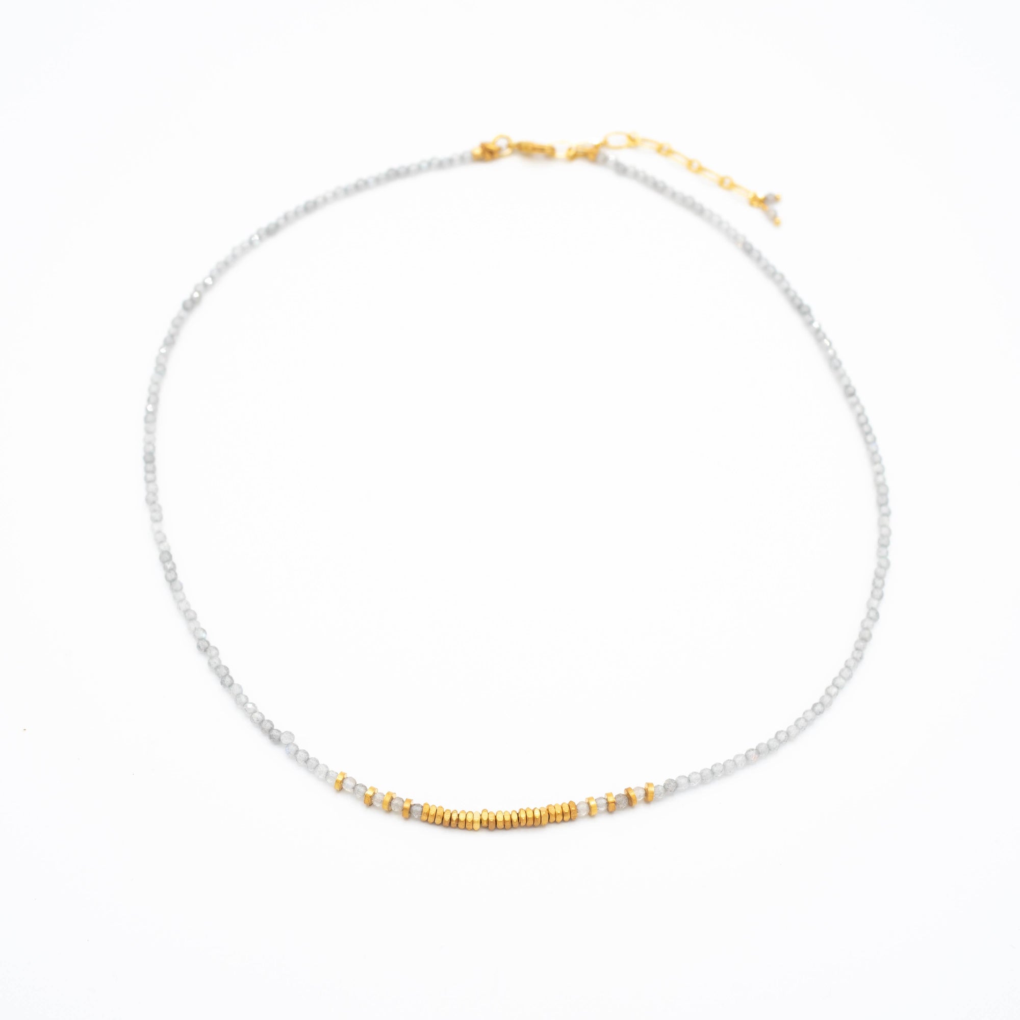 Necklace with white beads and gold accents on a white background