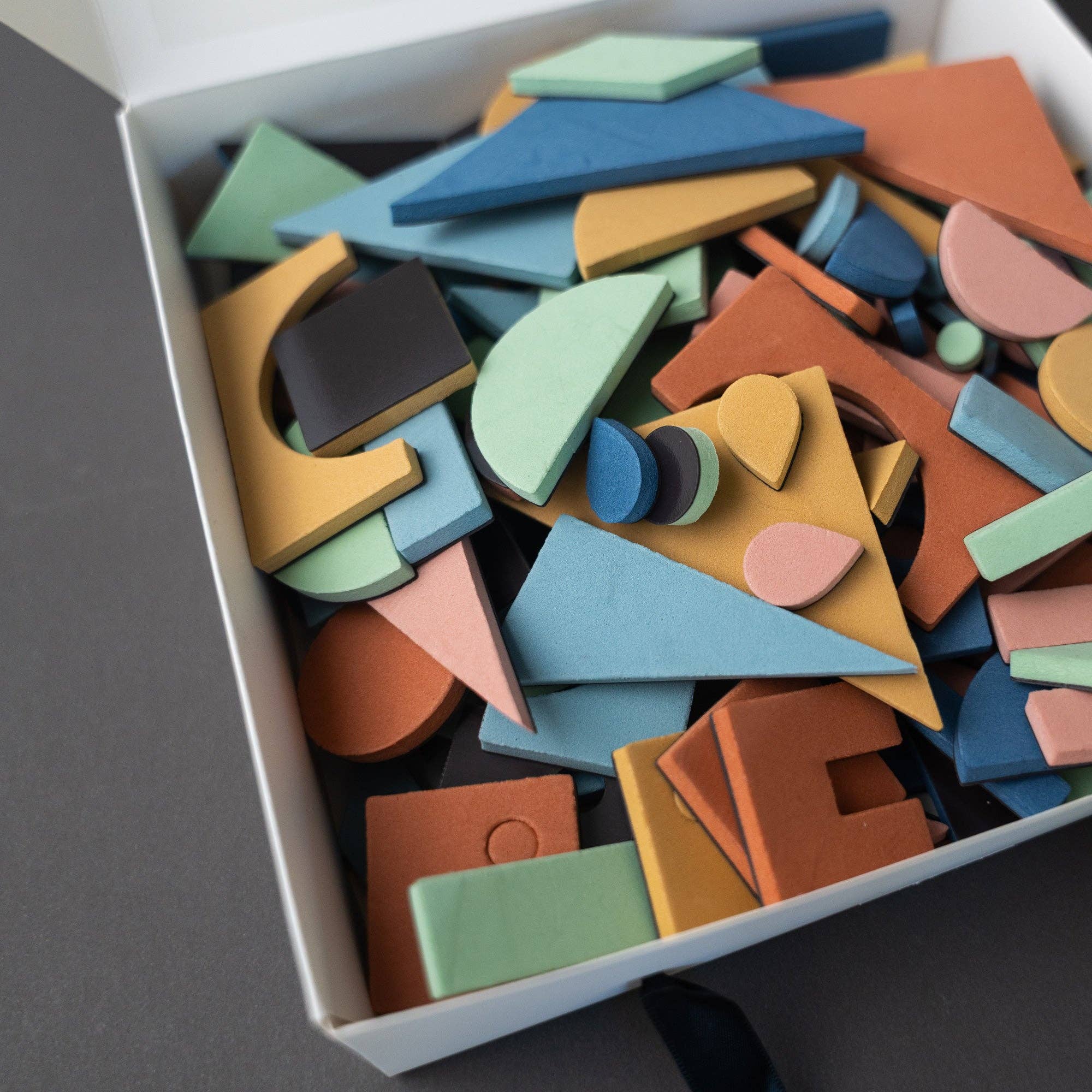Colorful wooden geometric shapes in a box