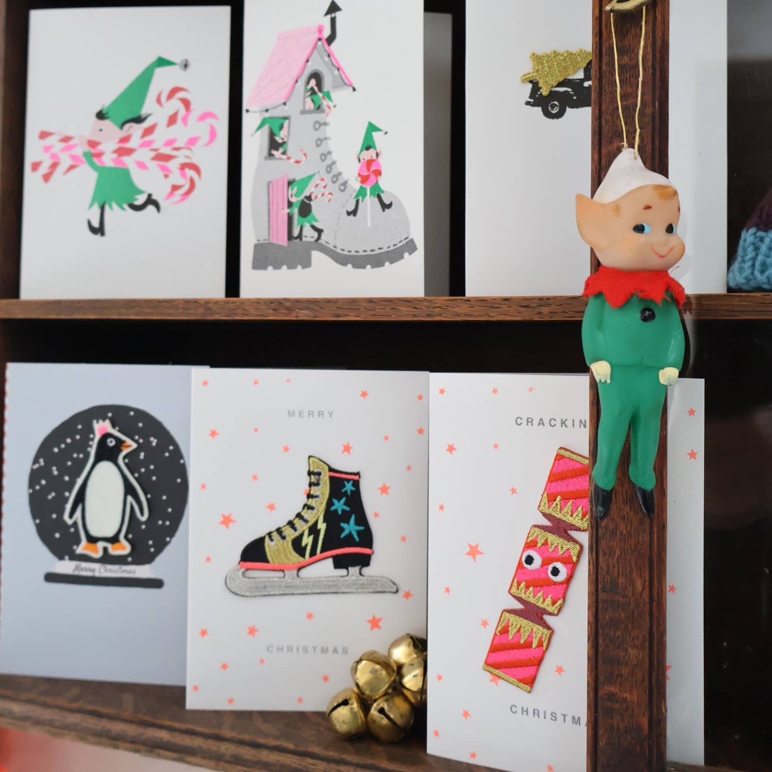 Collection of Christmas cards on a shelf with a decorative elf figure.
