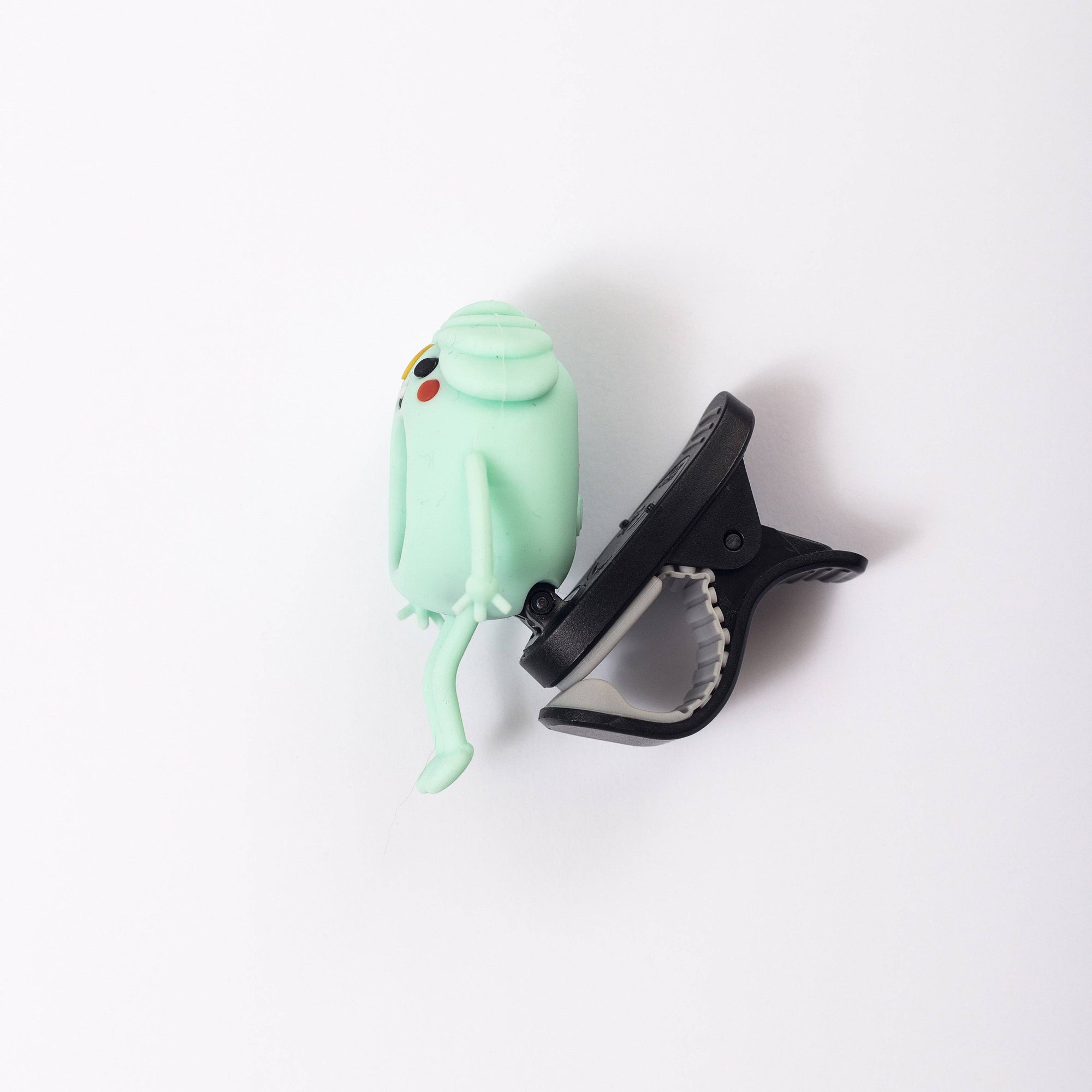 Mint green bird-shaped clip and black clip on a white background