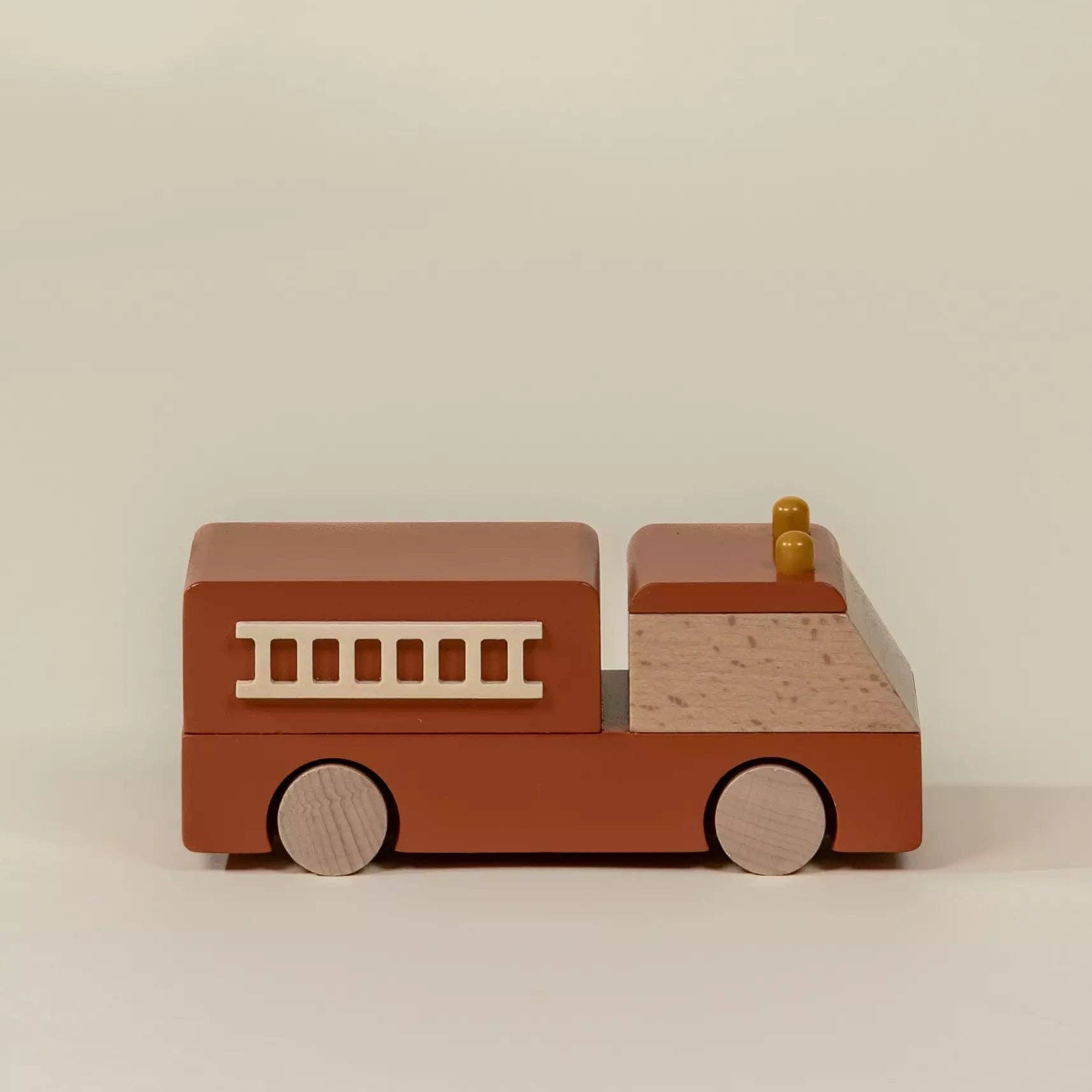 Wooden toy fire truck on a beige background