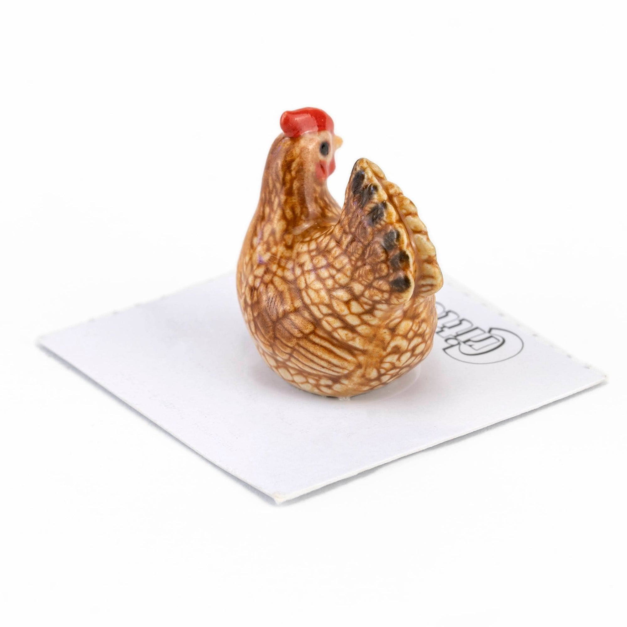 Chicken-shaped salt and pepper shaker on a white napkin with a brand logo.