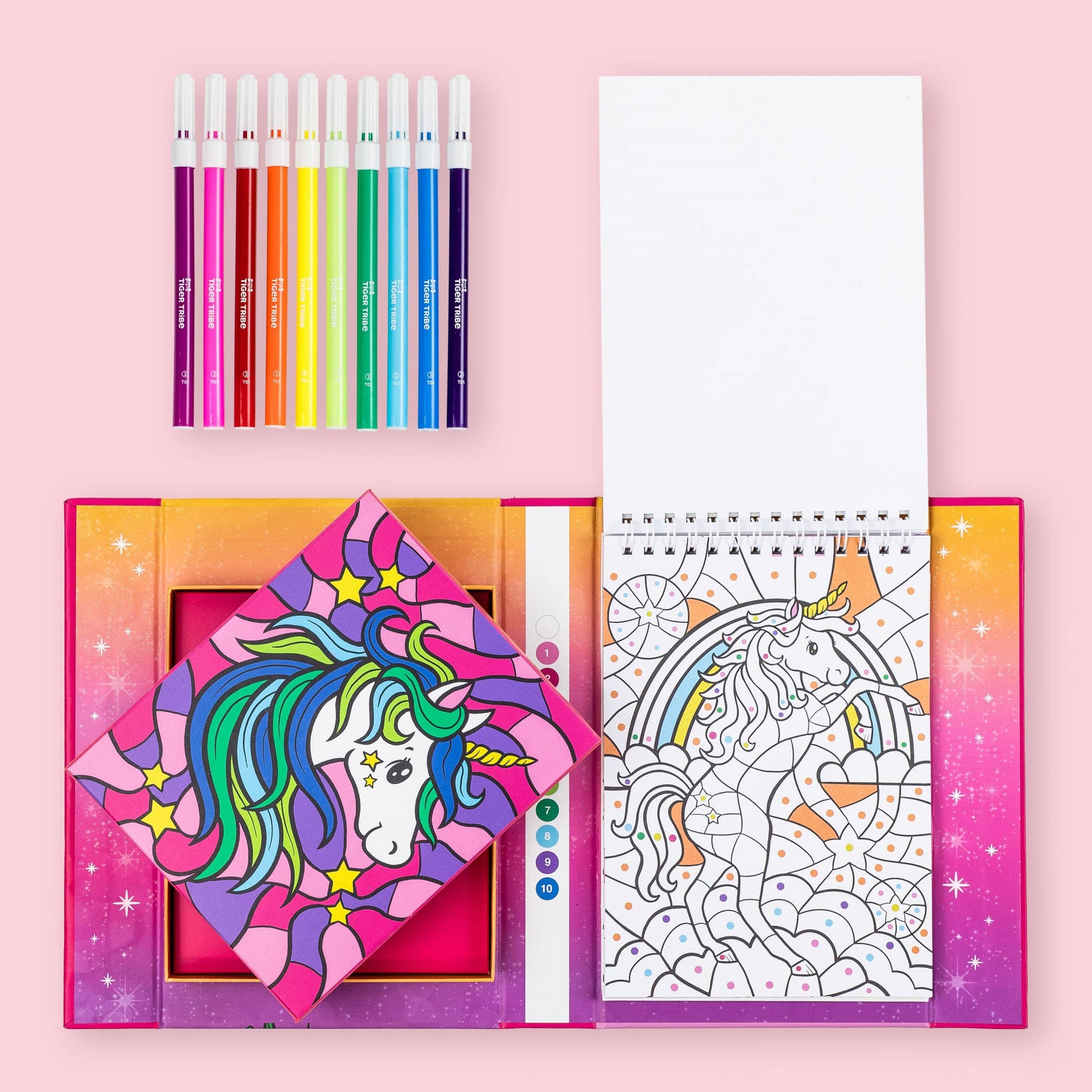 Coloring book set with colored pencils and a unicorn-themed coloring page on a pink background