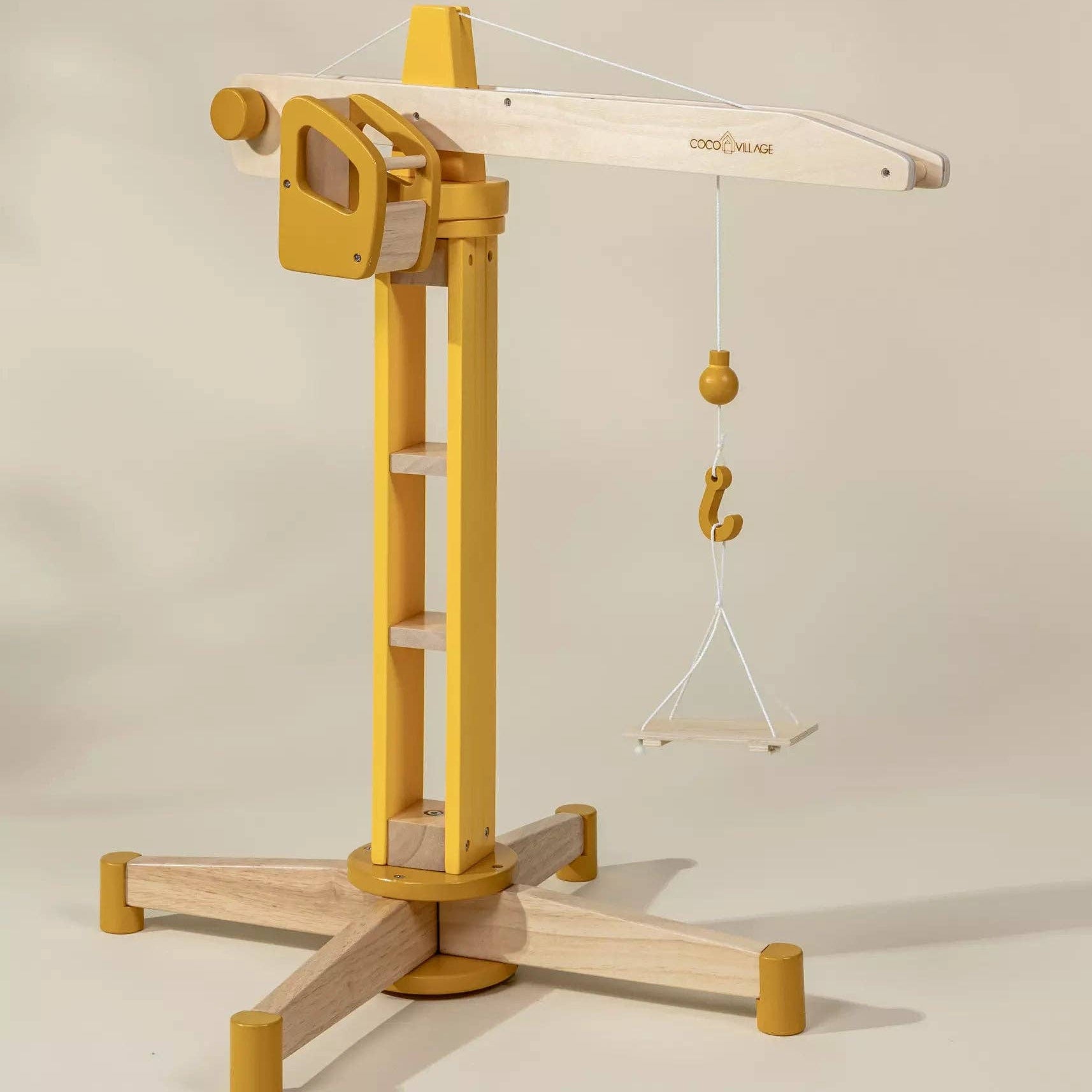 Wooden toy crane on a light gray background