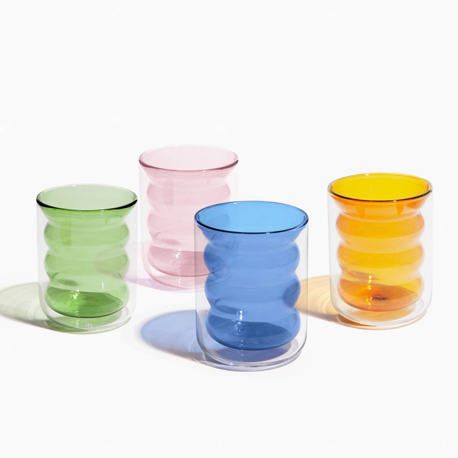 Four colorful glass tumblers on a white background