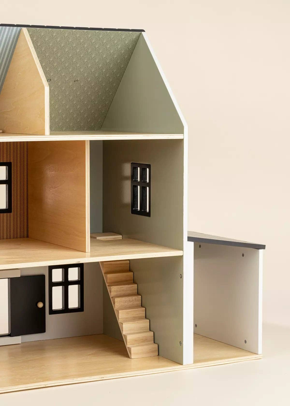 Model of a dollhouse with wooden staircase and detailed interior on a neutral background