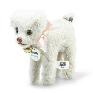 White plush dog with a pink bow on a white background