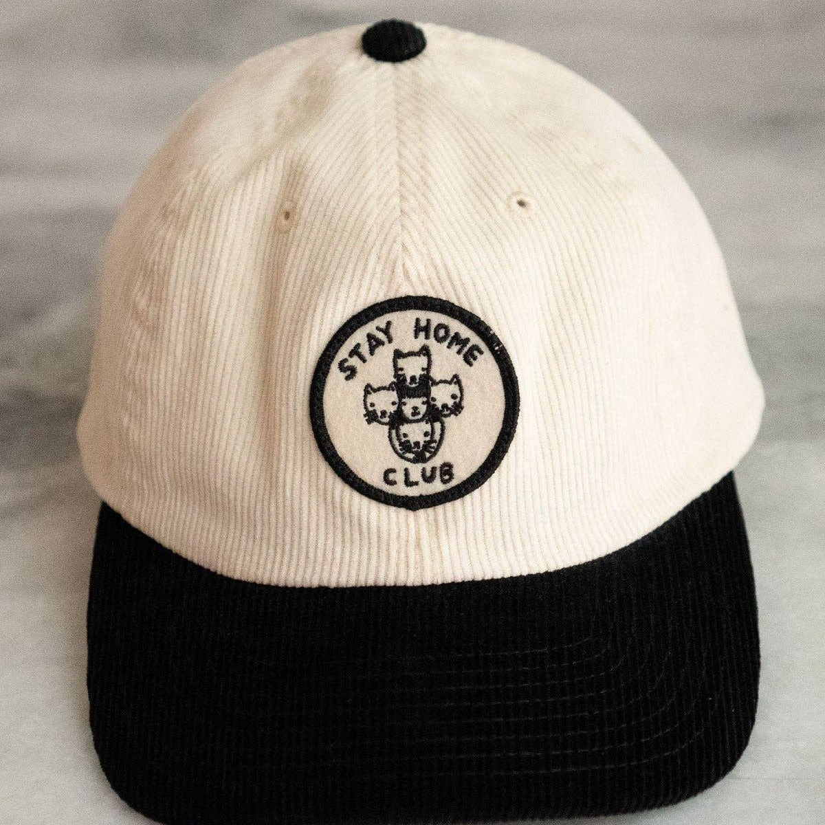 Cap with 'Stay Home Club' logo on a gray background