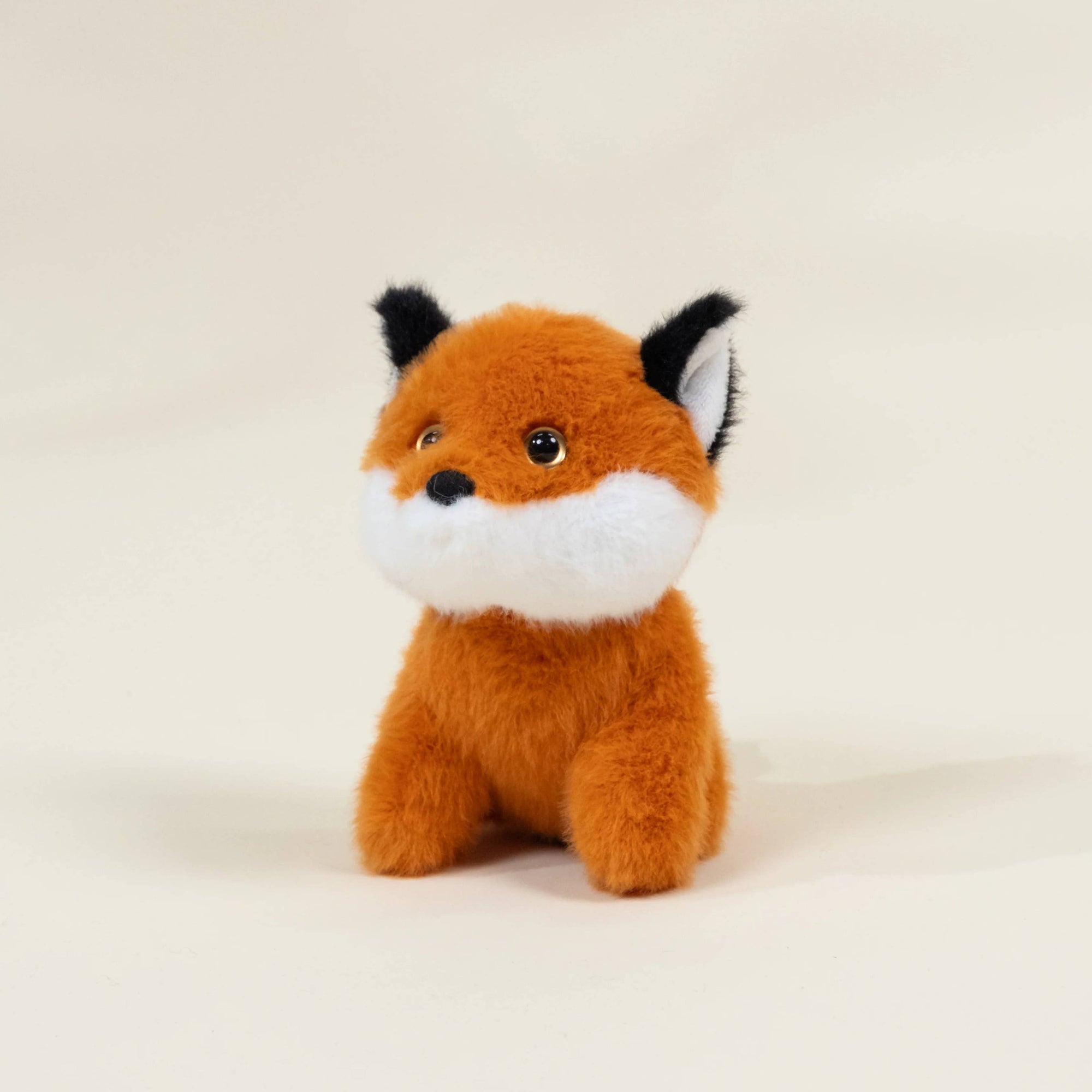 Plush fox toy on a beige background