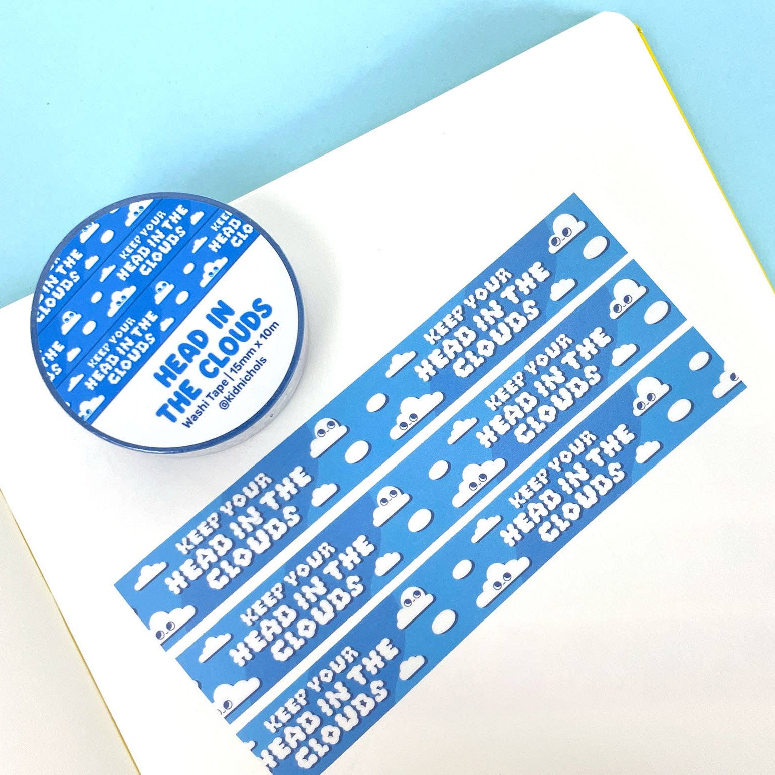 Blue and white motivational sticker set with 'Keep your head in the clouds' text on a white surface.