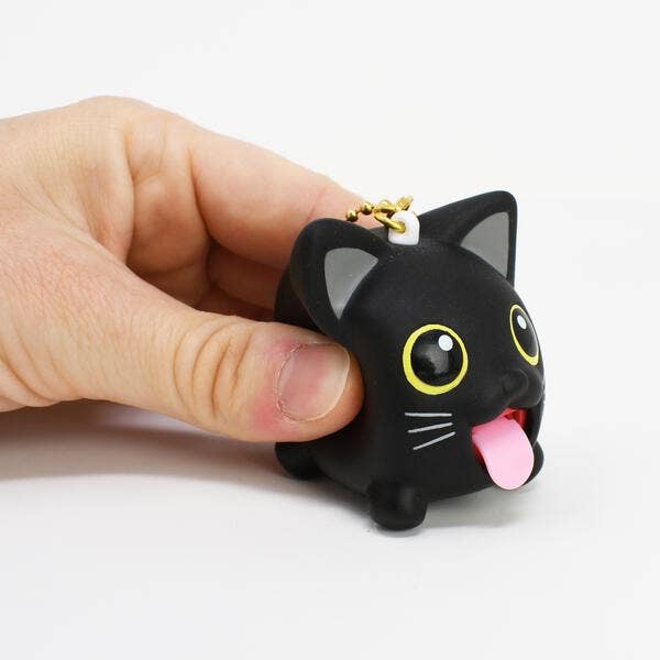 Black cat-shaped keychain with a hand holding it on a white background