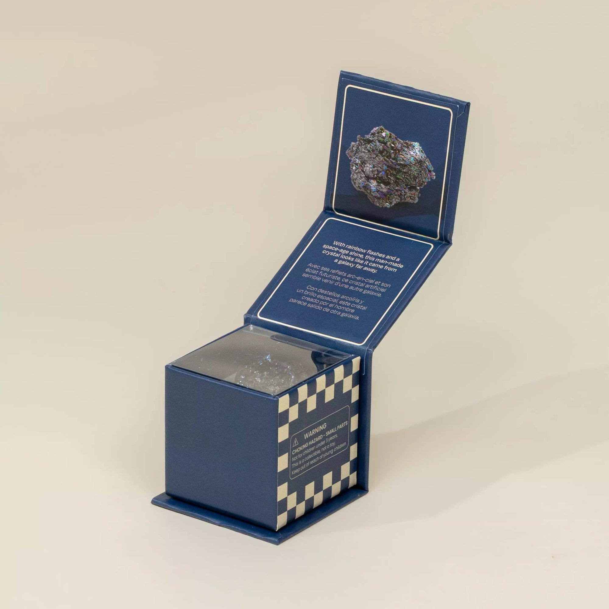 Open blue box with a checkered pattern containing a small object on a beige background