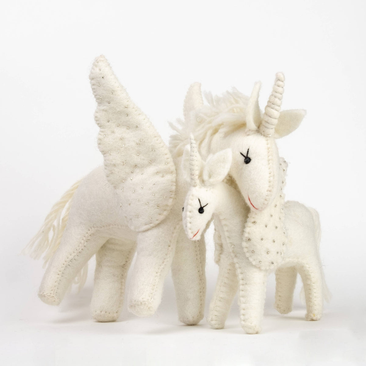 Two white unicorn toys with wings on a light gray background