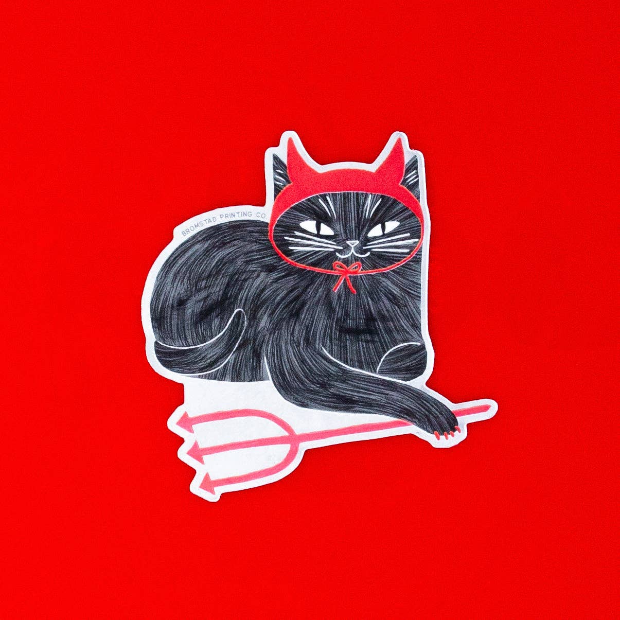 Illustration of a black cat with a red devil hat on a red background