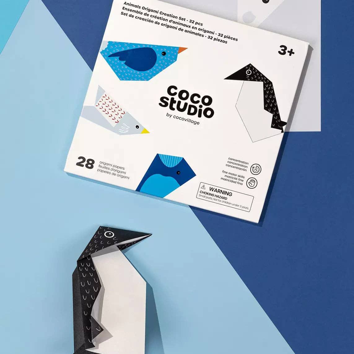 Coco Studio origami kit with a completed paper penguin on a blue background