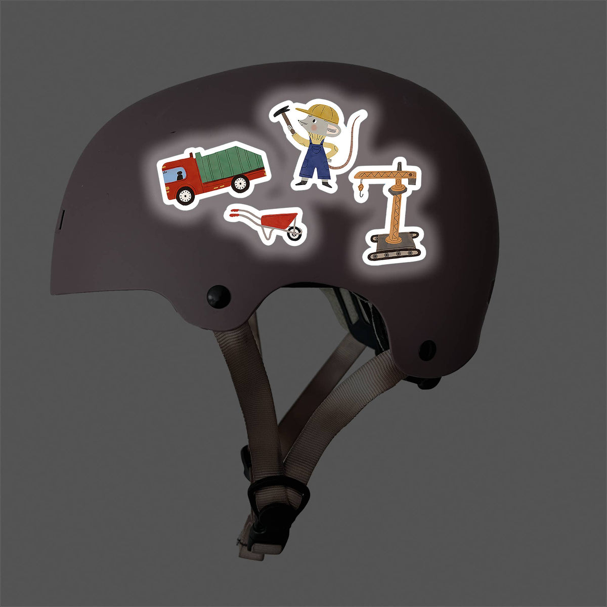 Dark helmet with construction-themed stickers on a dark background