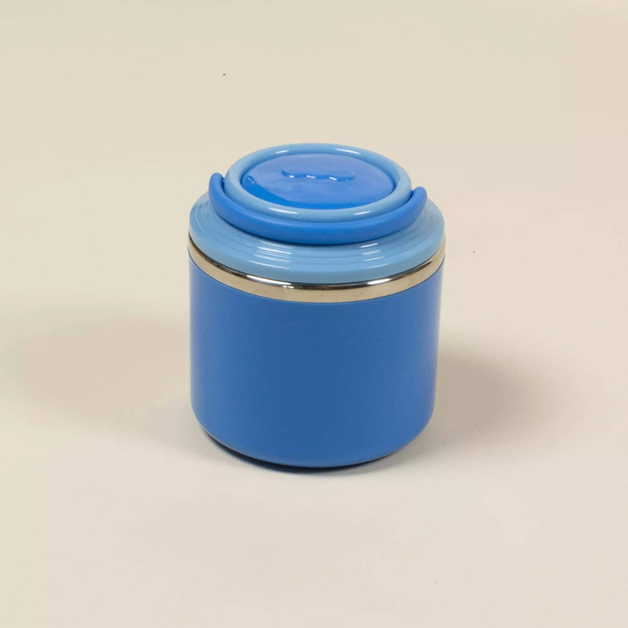 Blue insulated mug with a lid on a beige background