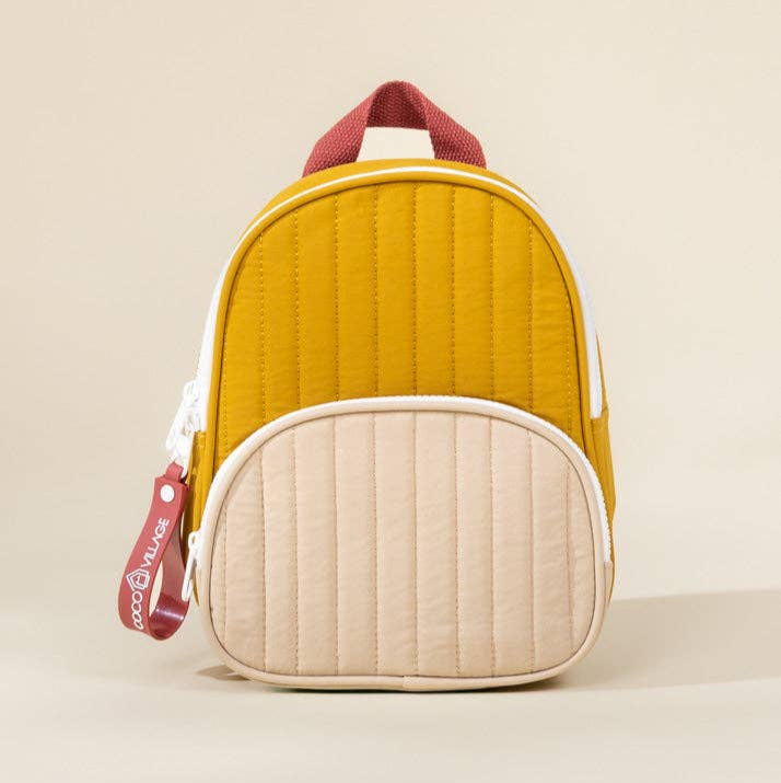 Yellow and beige quilted backpack with red accents on a beige background