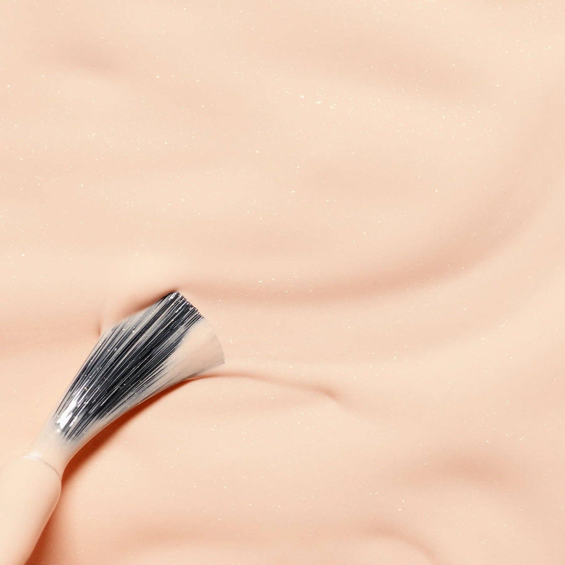 Makeup brush on a soft pink background