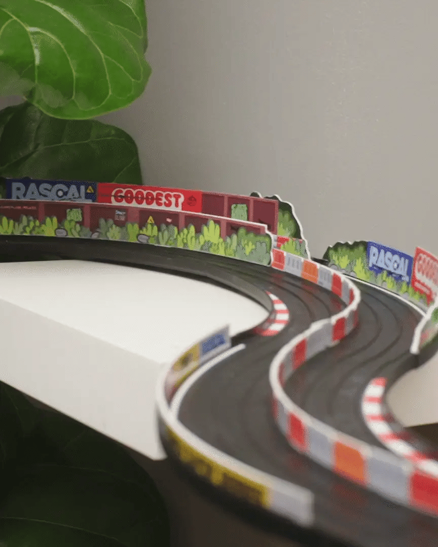 Model of a race track with colorful barriers and 'Rascal' branding.