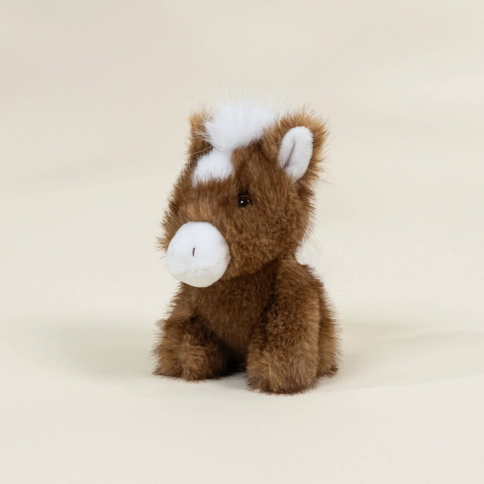 Plush horse toy on a beige background