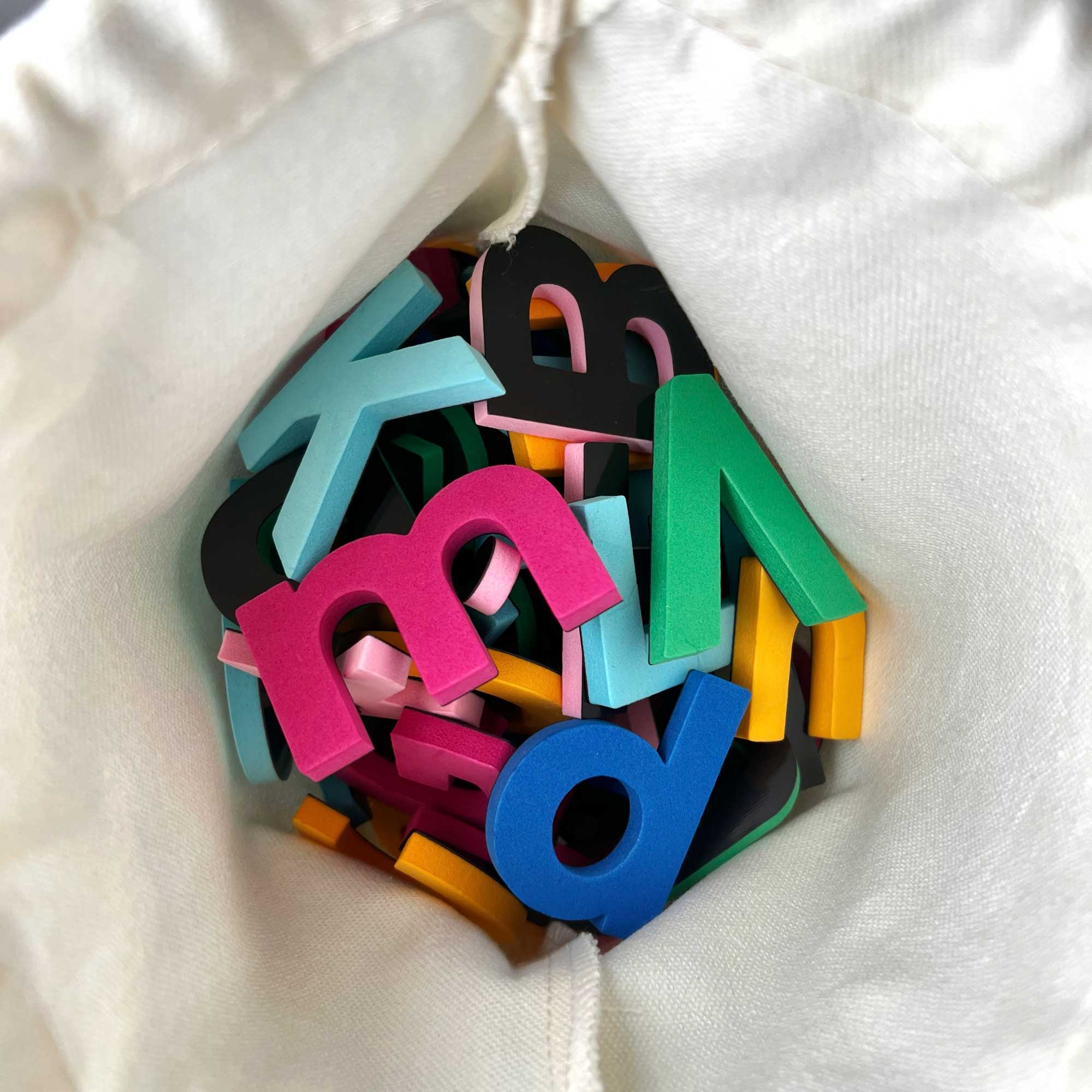 Colorful letter-shaped objects on a white fabric background