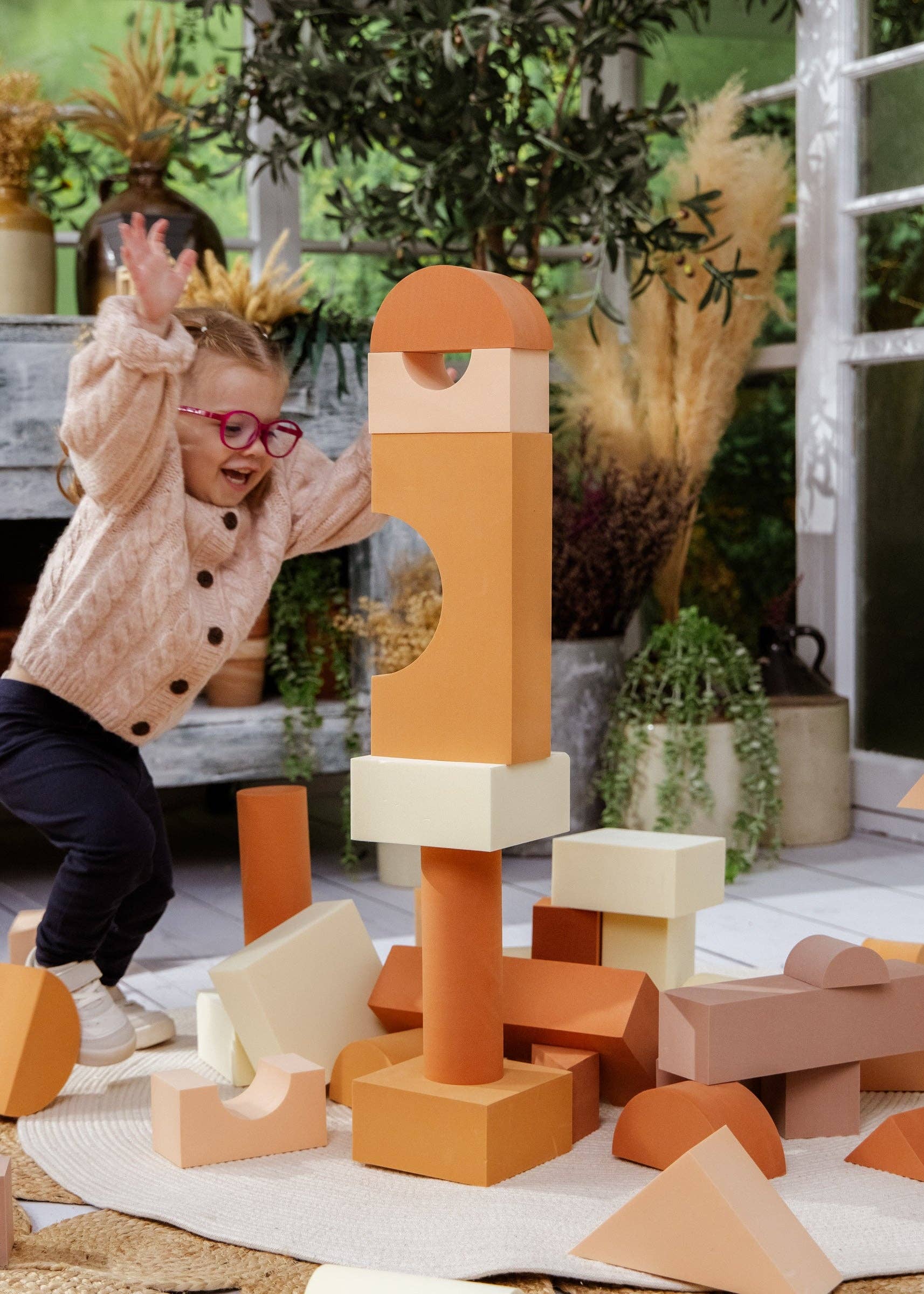 Child playing with colorful building blocks in an outdoor setting