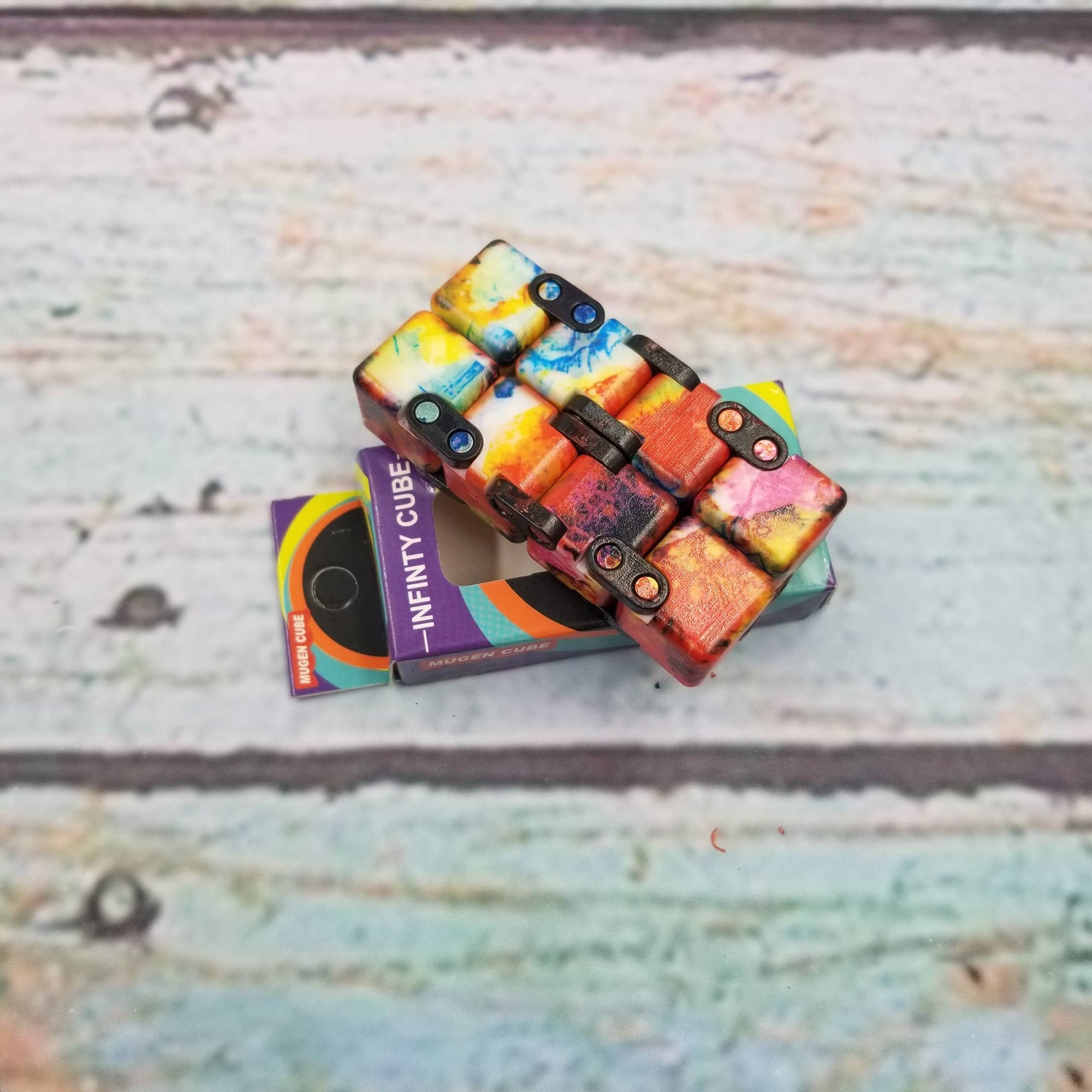 Colorful puzzle cube with packaging on a textured surface