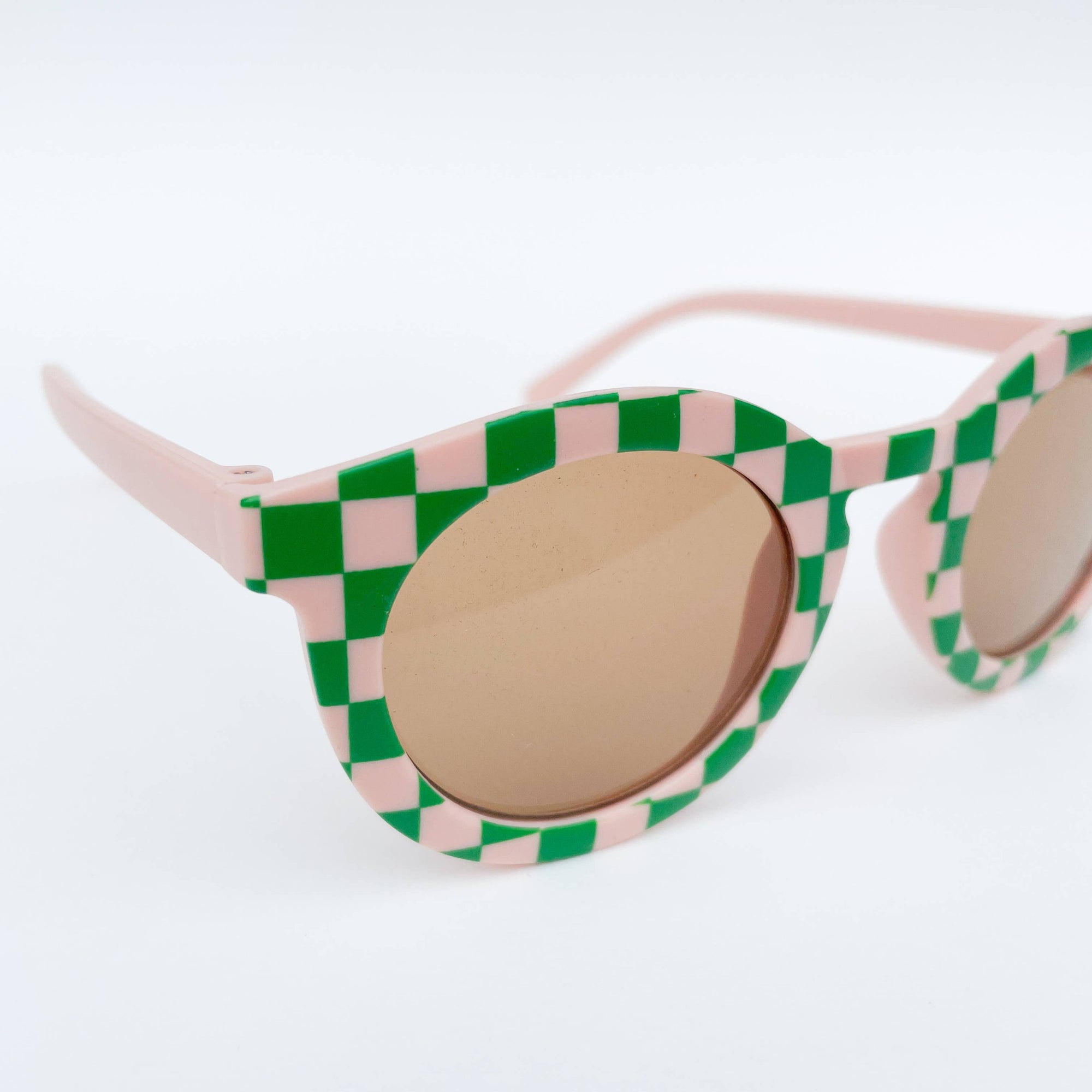 Sunglasses with green and pink checkered frame on a white background