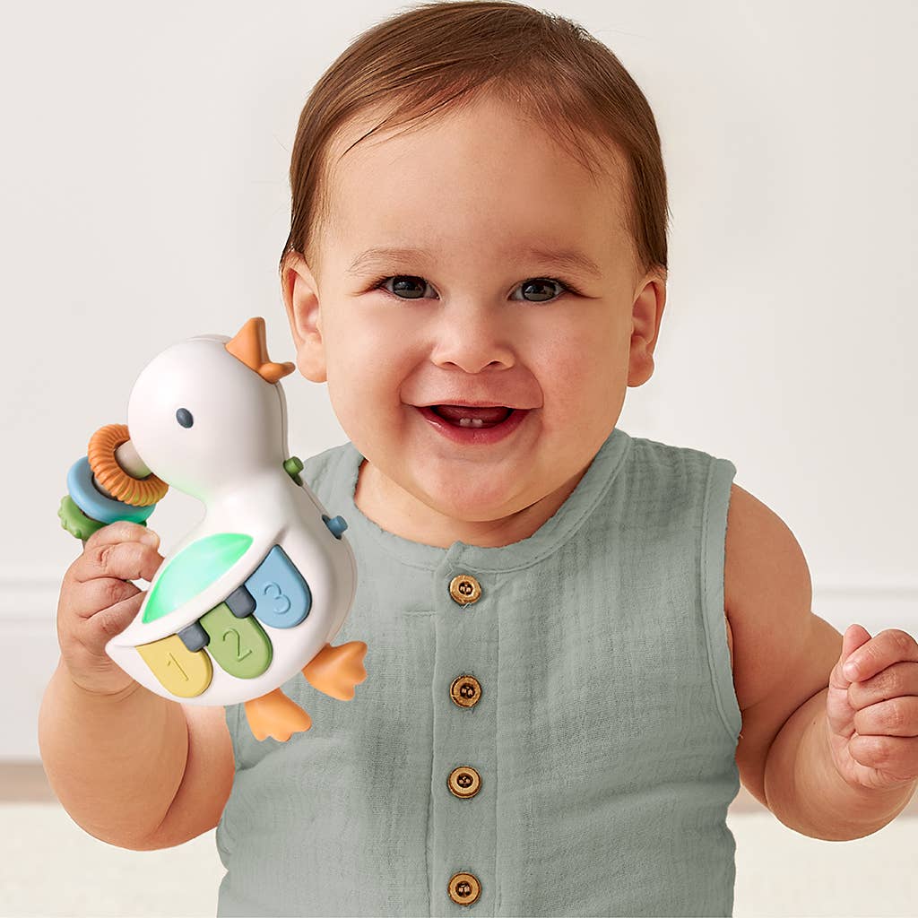Baby holding a colorful toy with a white background