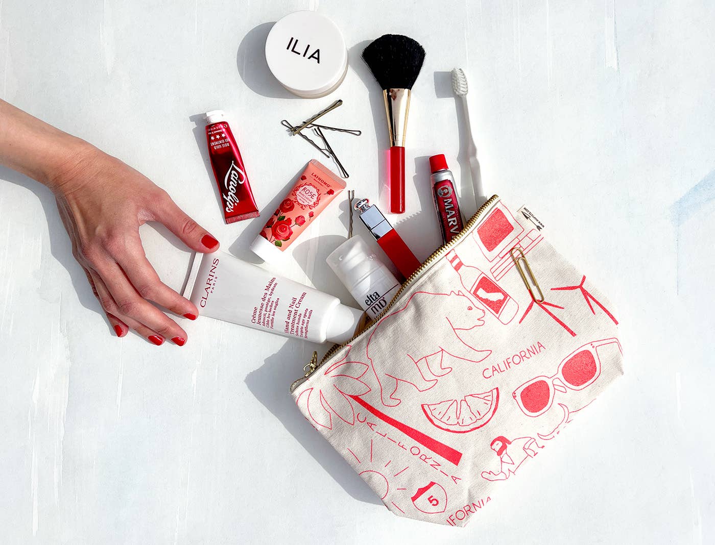 Makeup products and a pouch with 'California' design on a white background