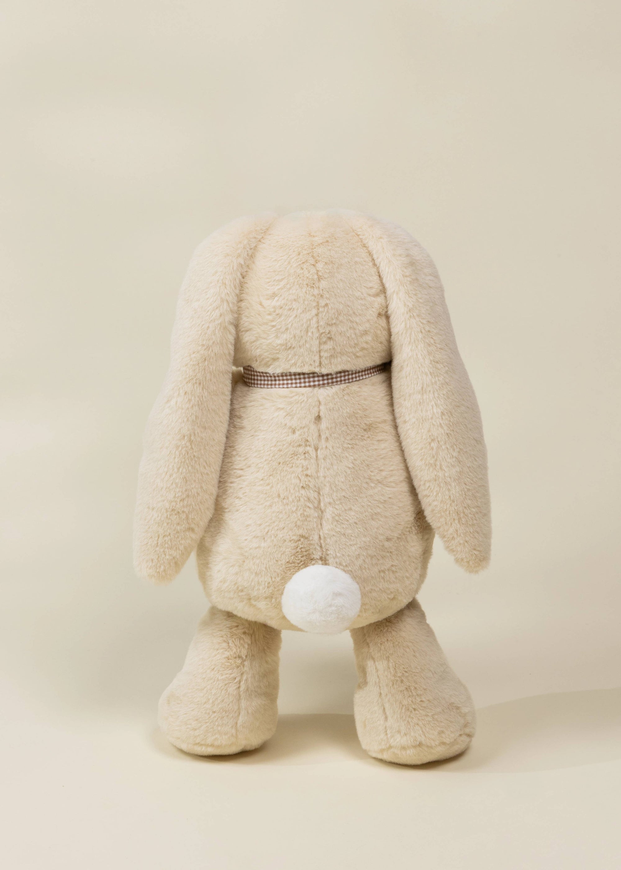 Beige plush bunny toy on a beige background