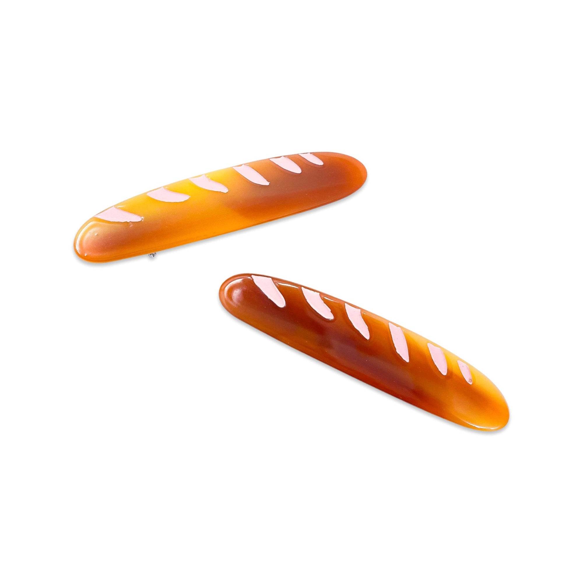 Two bread-shaped hair clips on a white background