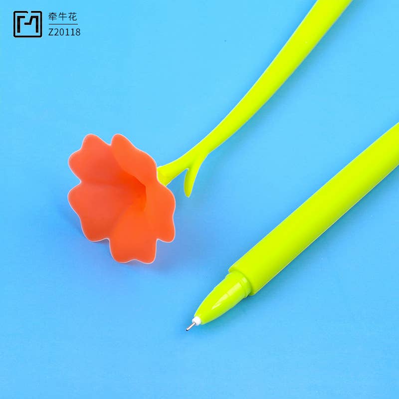 Green pen with orange flower-shaped clip on a blue background