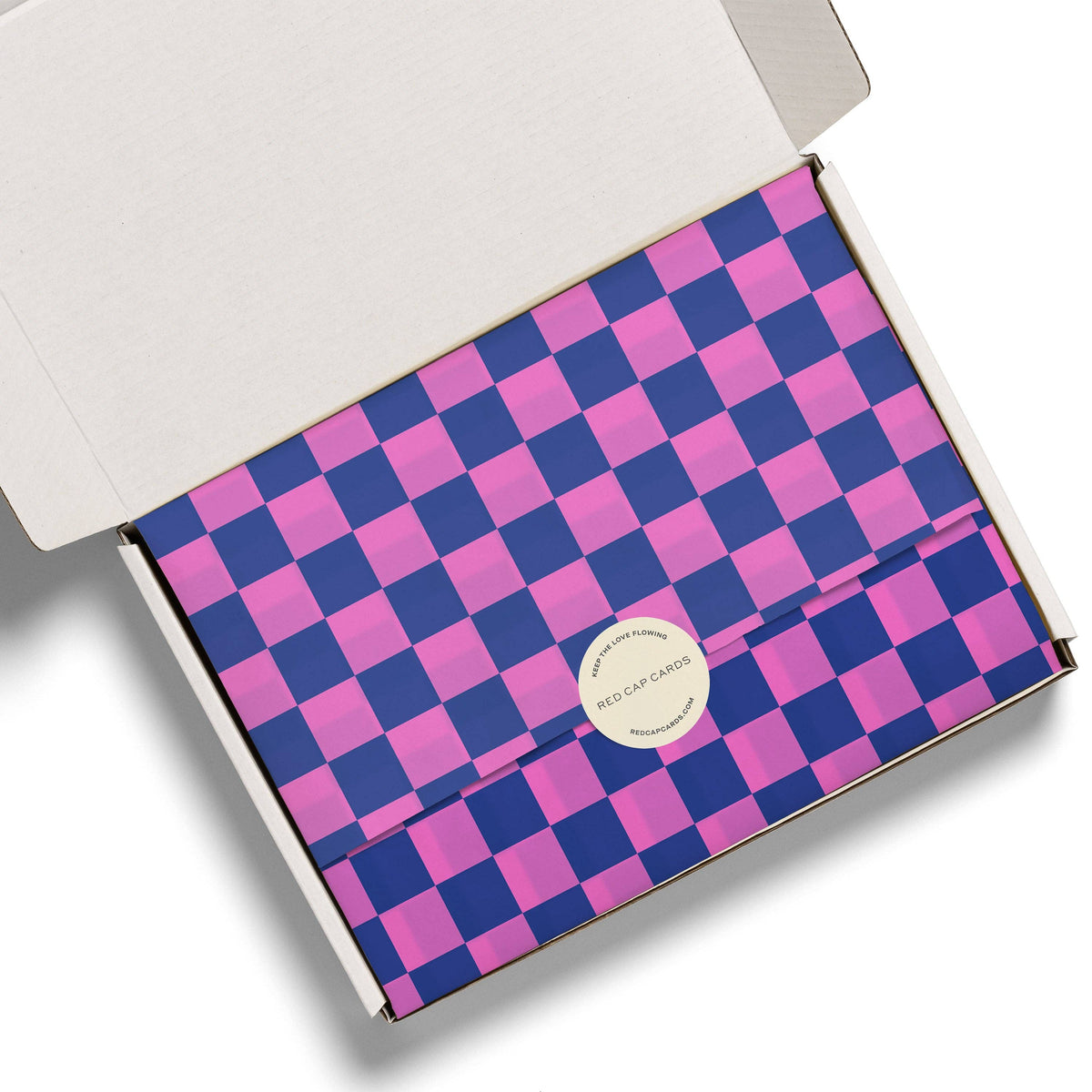 Checkered box with pink and blue pattern and a visible brand logo on a white background