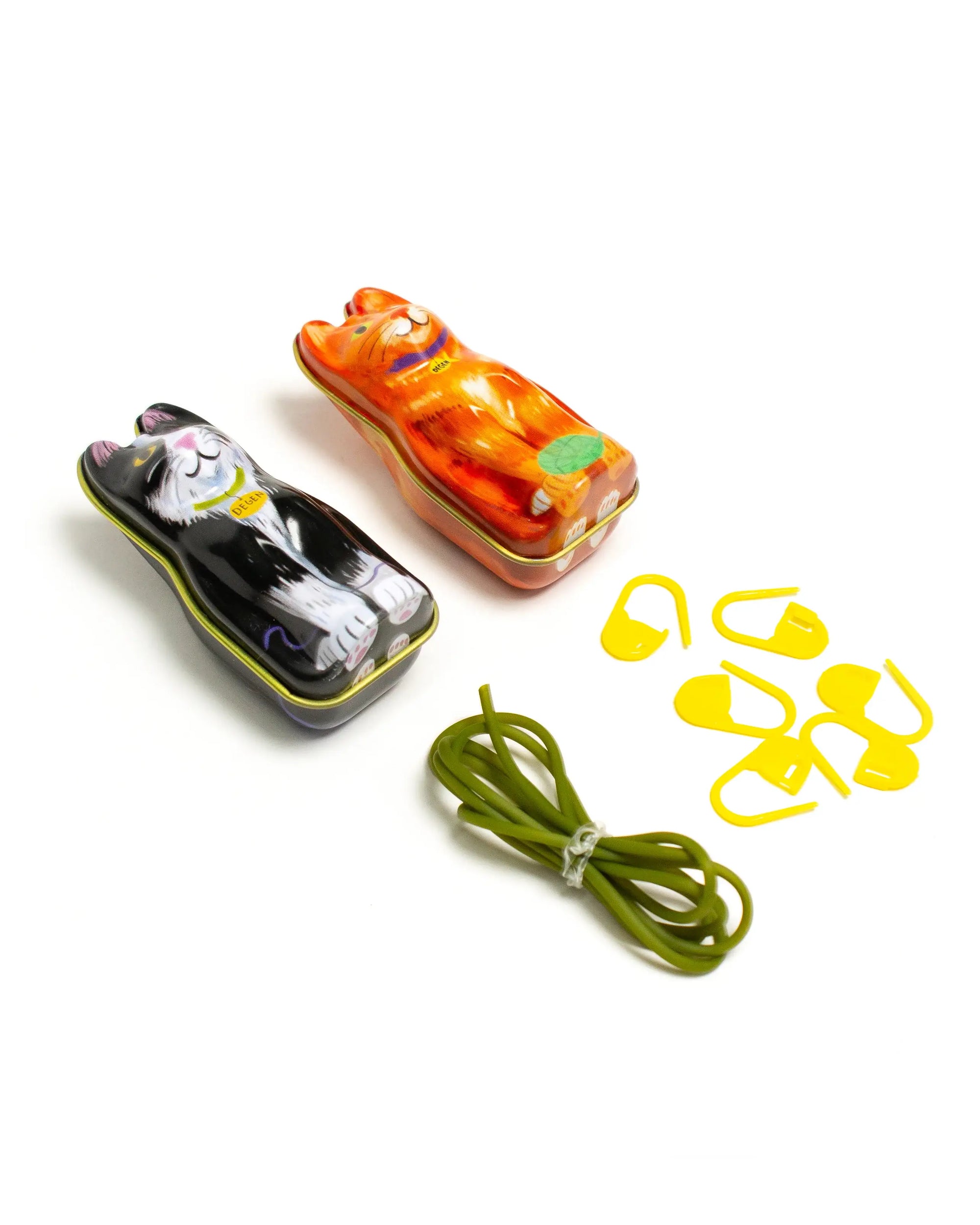 Cat-shaped containers with a green string and yellow clips on a white background