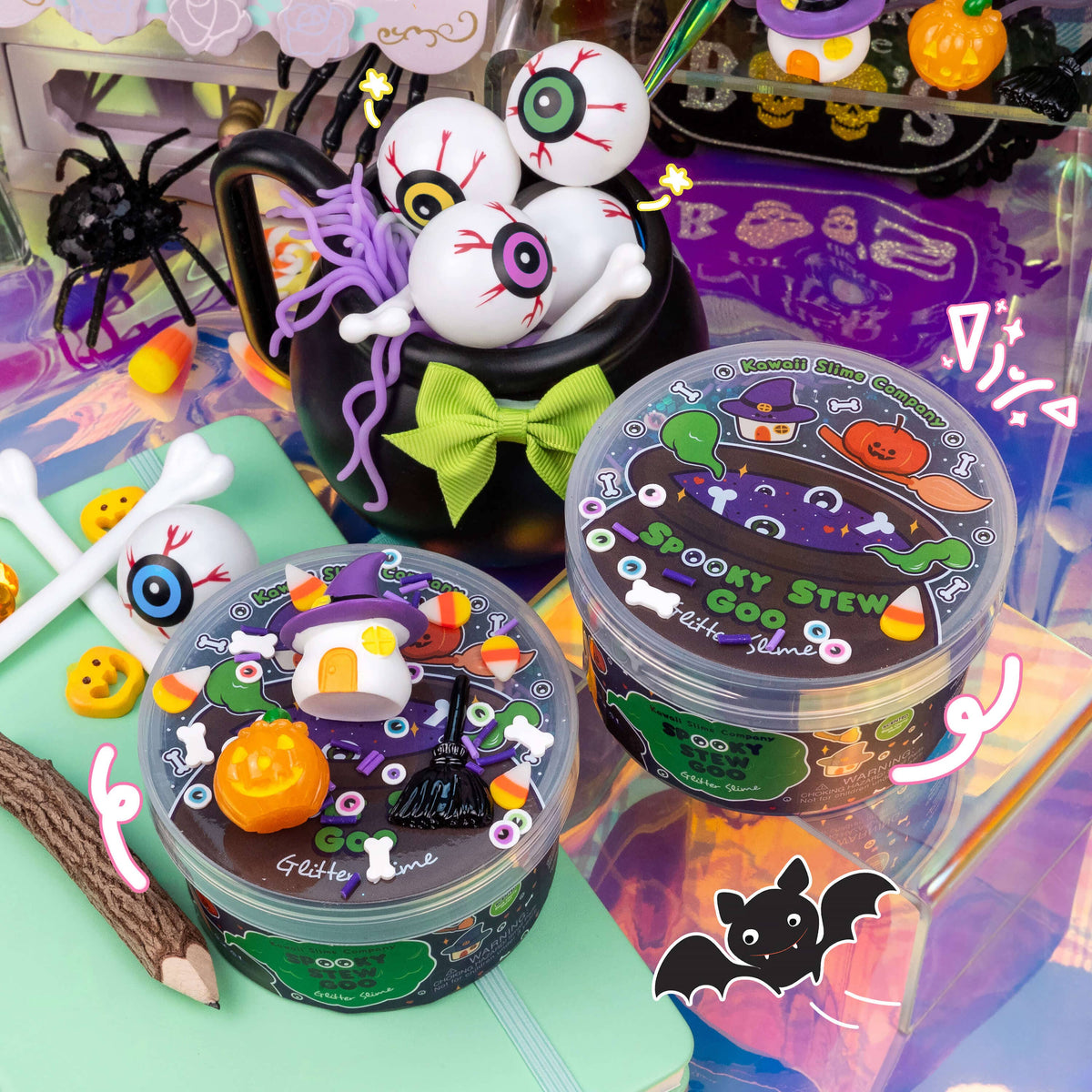 Two clear plastic jars of GGLS 'Spooky Stew' slime displayed on a colorful, themed background with Halloween props like a cauldron, eyeballs, and pumpkins.