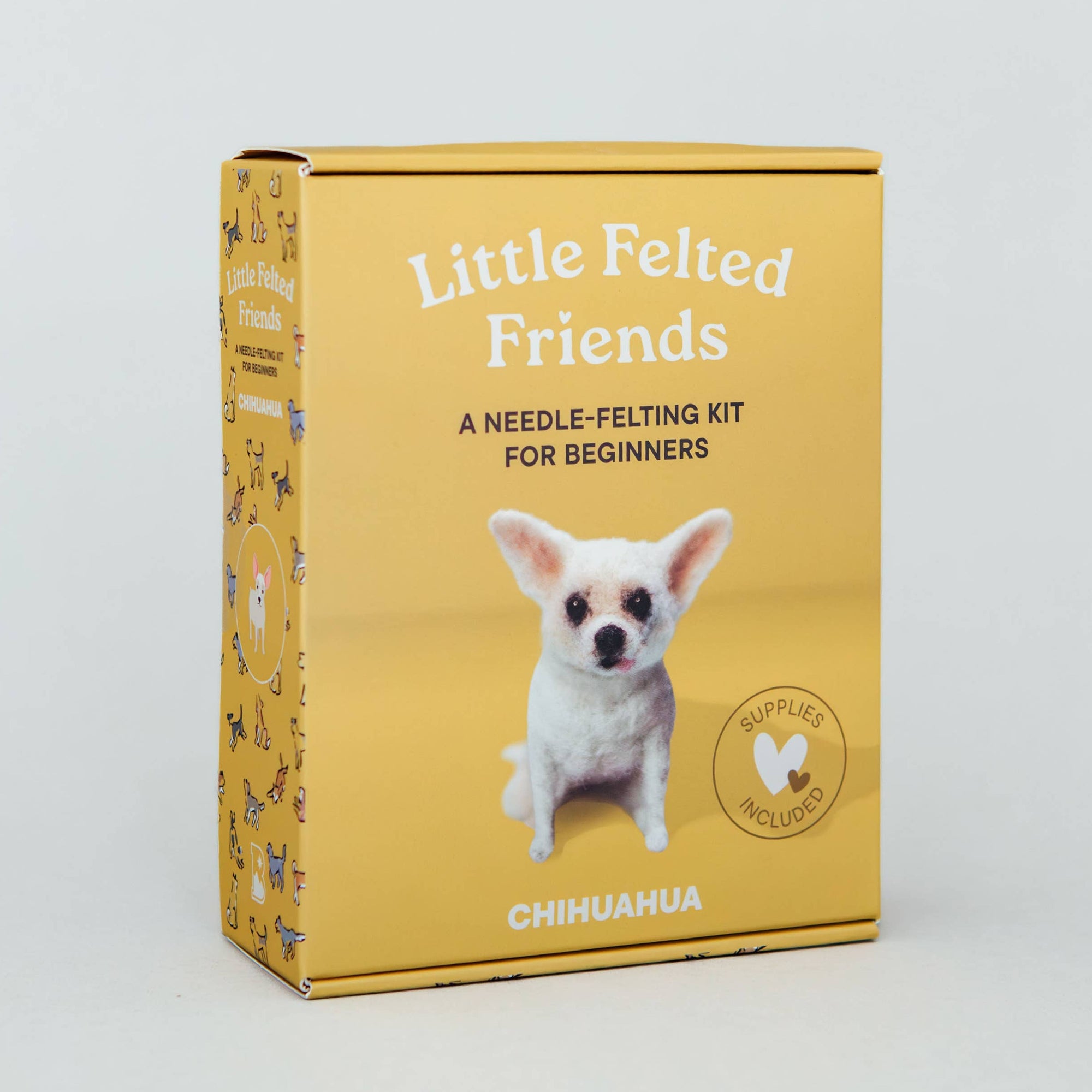A yellow box for a needle felting kit titled 'Little Felted Friends' with a photo of a small white dog on the front, photographed against a light gray studio background.