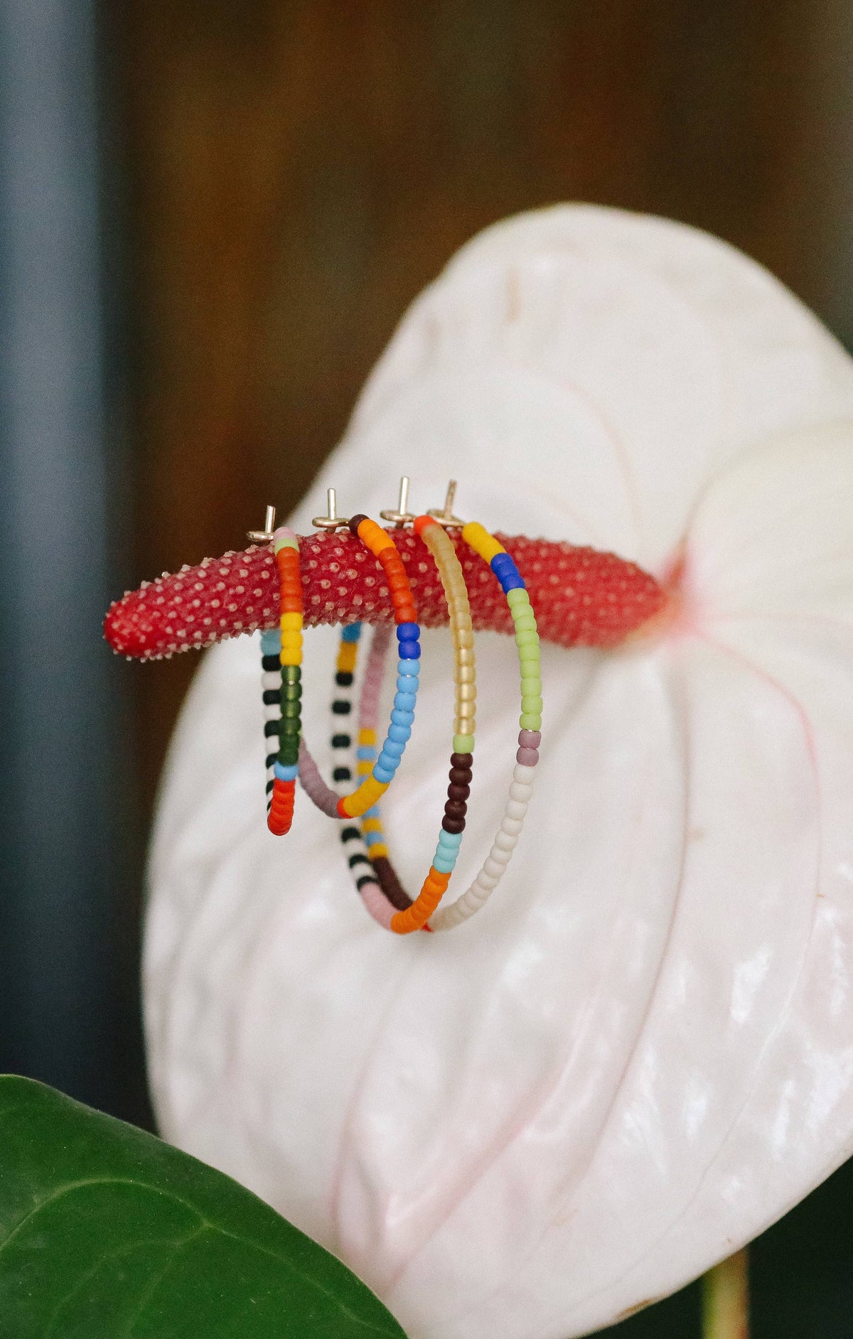 Colorful beaded hair clips on a white flower with a blurred background